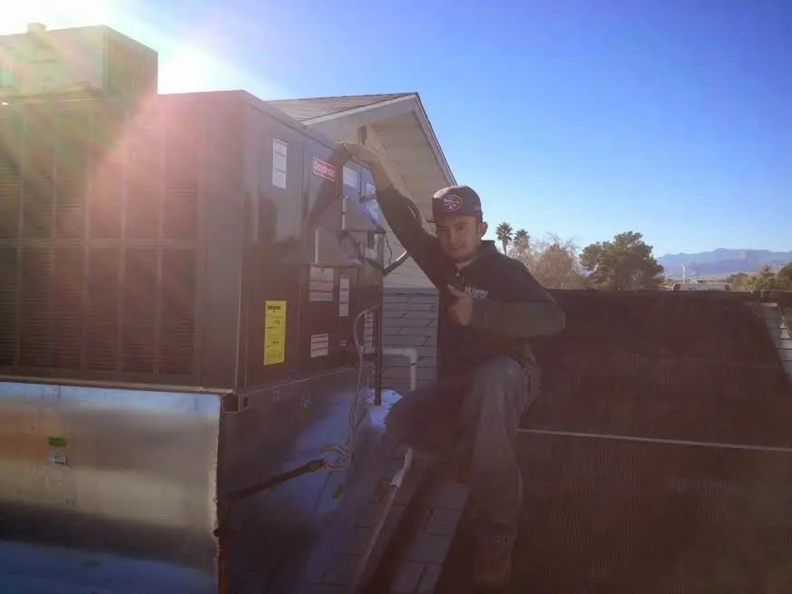 HVAC technician performing HVAC Inspection on a rooftop unit in Morris
